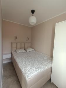 een witte slaapkamer met een bed in een kamer bij Spokojny Brzeg in Kołobrzeg