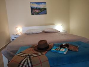 Dormitorio con cama con sombrero y libro en Oliva Apartments Lozica, en Dubrovnik