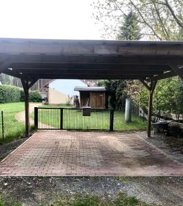 een paviljoen in een park met een hek en een bank bij Ferienhaus am Netzener See in Lehnin