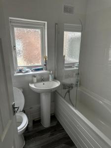 een badkamer met een wastafel, een toilet en een douche bij Muram Properties in Kirkby
