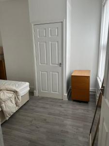 een slaapkamer met een deur, een bed en een dressoir bij Muram Properties in Kirkby