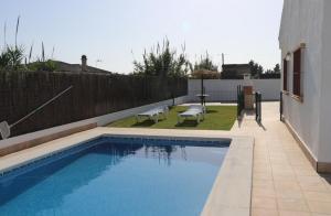 a swimming pool in the backyard of a house at Chalet Playa Roche in Roche