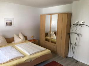 a bedroom with a bed and a wooden cabinet at Appartementhaus Christiansen in Timmendorfer Strand