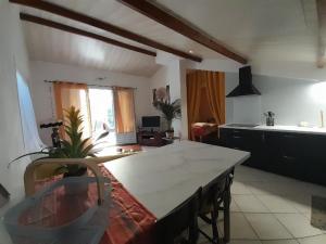 een keuken met een grote witte tafel in een kamer bij Gîte Douceur de vivre in Saint-Avaugourd-des-Landes