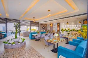 a restaurant with blue couches and tables and chairs at Greenwood Villa By Levelup in Amritsar