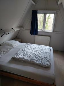 a bed in a small room with a window at Chalet 176 in Durbuy +27 photos