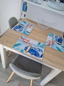 une table avec une chaise et une table avec une couverture de voiture dans l'établissement Trimaran Studio 10 mètres de la plage avec balcon/terrasse, à Mers-les-Bains