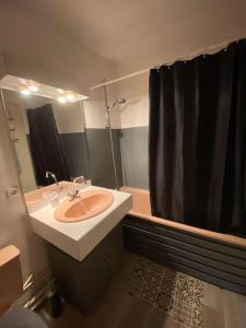 La salle de bains est pourvue d'un lavabo et d'un rideau de douche noir. dans l'établissement Trimaran Studio 10 mètres de la plage avec balcon/terrasse, à Mers-les-Bains
