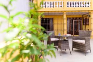 a patio with chairs and a table in front of a yellow building at Newly renovated & cozy apartment in Antananarivo