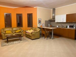 a living room with two chairs and a table in a kitchen at The Orange House in Assemini