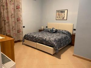 ein Schlafzimmer mit einem Bett mit einer Decke darauf in der Unterkunft The Orange House in Assemini