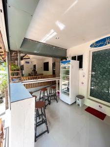 a restaurant with a counter with stools and a refrigerator at Magic Hostel in Phi Phi Don