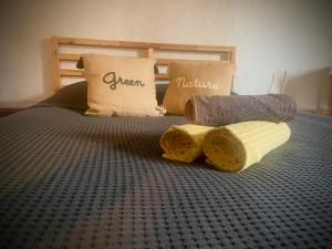 uma cama com duas almofadas e toalhas em Studio Nature, proche du centre-ville em Dijon