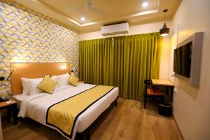 um quarto de hotel com uma cama e uma cortina verde em Regenta Inn Bannerghatta Bangalore em Bangalore