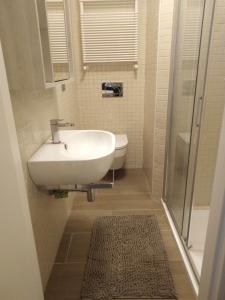 a bathroom with a white sink and a shower at AFFITTACAMERE PIAZZA UNITA' in Monfalcone