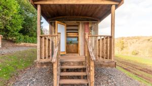 a tiny house with a staircase leading to the door at Betty Shepherd's Hut in Lydney