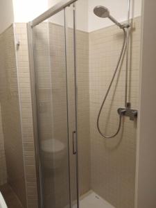 La salle de bains est pourvue d'une douche avec une porte en verre. dans l'établissement AFFITTACAMERE PIAZZA UNITA', à Monfalcone
