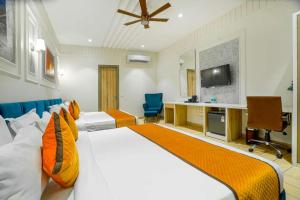 a hotel room with a large bed and a desk at Greenwood Villa By Levelup in Amritsar