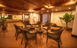 a lobby with chairs and tables and a room at Treasure Hotel Laos in Luang Prabang