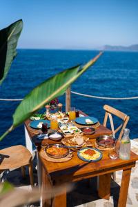 a wooden table with food on top of the ocean at Zakros Hotel Lykia in Faralya