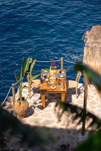 a table with food on it next to the water at Zakros Hotel Lykia in Faralya