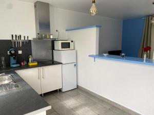 uma cozinha com um frigorífico branco e um micro-ondas em L'estran em Marennes