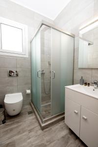 a bathroom with a shower and a toilet and a sink at Maria Studios & Apartments in Kremasti