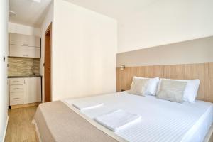 a bedroom with a large white bed with white pillows at Symphony Apartments Street View in Petrovac na Moru +3 photos