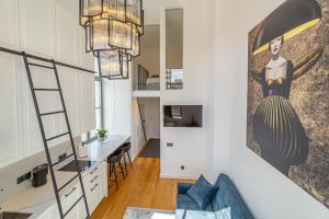 Habitación con escalera y sala de estar con cocina. en Ministerija Loft Apartment with parking & AC, en Kaunas