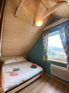 a small bed in a room with a window at Leśna Ostoja in Lubawka