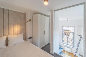 - une chambre avec un grand lit et une fenêtre dans l'établissement Ministerija Loft Apartment with parking & AC, à Kaunas