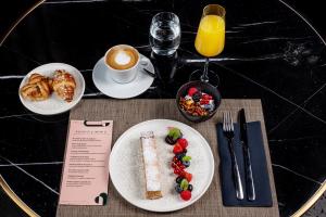 a table with plates of food and a cup of coffee at Ego SPA in Bir&scaron;tonas