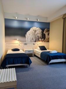 a room with two beds and a rock wall at Hotel Morski Gdynia in Gdynia