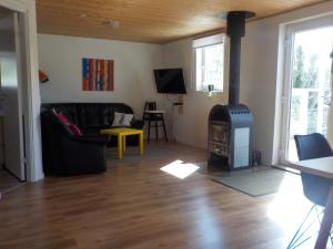 uma sala de estar com um fogão a lenha em Lyngsasgaard M em Sæby