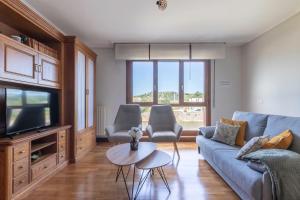 salon z niebieską kanapą i telewizorem w obiekcie Confort junto a la Ría de Barakaldo w mieście Barakaldo