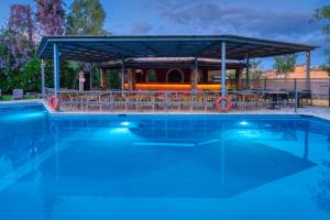 a swimming pool with a gazebo and a picnic table at Folies Corfu Town Hotel Apartments in Corfu Town
