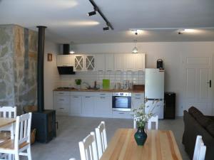 kuchnia i salon ze stołem i lodówką w obiekcie Dom z Zielonego Wzgórza 