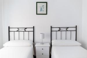 1 dormitorio con 2 camas y mesita de noche con lámpara en Apartamento Antonio - Puerto Pollensa, en Puerto Pollensa