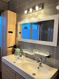 een badkamer met een wastafel en een spiegel bij Cosy maison in Oupeye