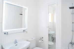 a white bathroom with a sink and a mirror at Apartamento Antonio - Puerto Pollensa in Port de Pollensa