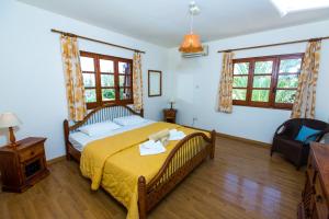 Villa Pomos Med. في بوموس: غرفة نوم بسرير كبير مع بطانية صفراء