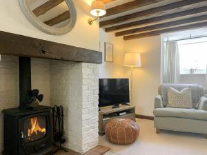 a living room with a fireplace and a television at Grain End in Sawdon