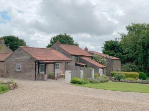 a row of brick houses with a gravel driveway at Grain End in Sawdon