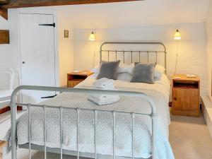 sypialnia z metalowym łóżkiem i 2 szafkami nocnymi w obiekcie Grain End w mieście Sawdon