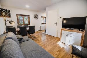 a living room with a couch and a flat screen tv at Holiday Home Kozorog in Bohinj
