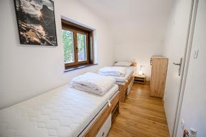 two beds in a room with a window at Holiday Home Kozorog in Bohinj +17 photos