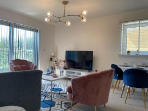 a living room with chairs and a tv and a table at Stylish Station Apartment in Rochester with Free Parking in Wainscot