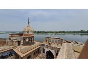 馬圖拉的住宿－Hotel Saurav Palace, Mathura，享有河上一座带塔楼的建筑的景色