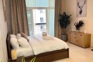 a bedroom with a bed with a window and a window at Yas Island Oasis Getaway 1BR Amazon in Abu Dhabi