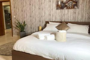 a white bed with two towels on it at Yas Island Oasis Getaway 1BR Amazon in Abu Dhabi